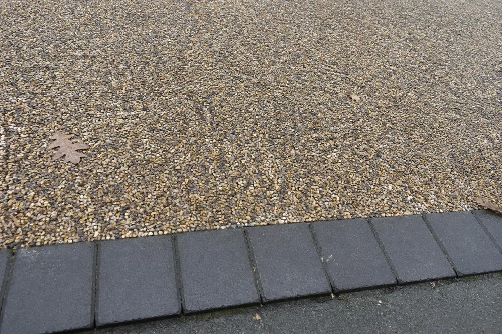 Close-up of resin-bound stone surface with a block paving edge